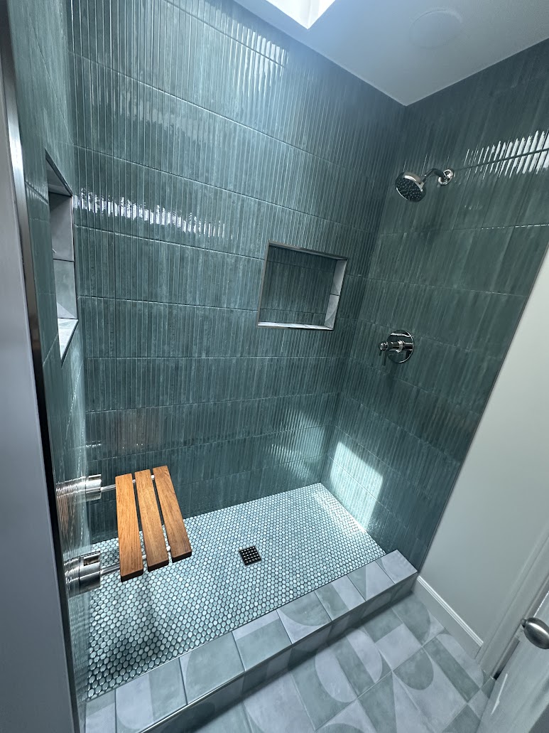 Fold-down wood bench inside tiled Vista master bathroom shower