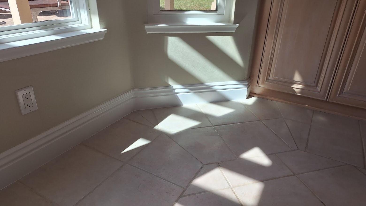 Reconstructed wall and white baseboards below windows beside cabinetry in Rancho Santa Fe